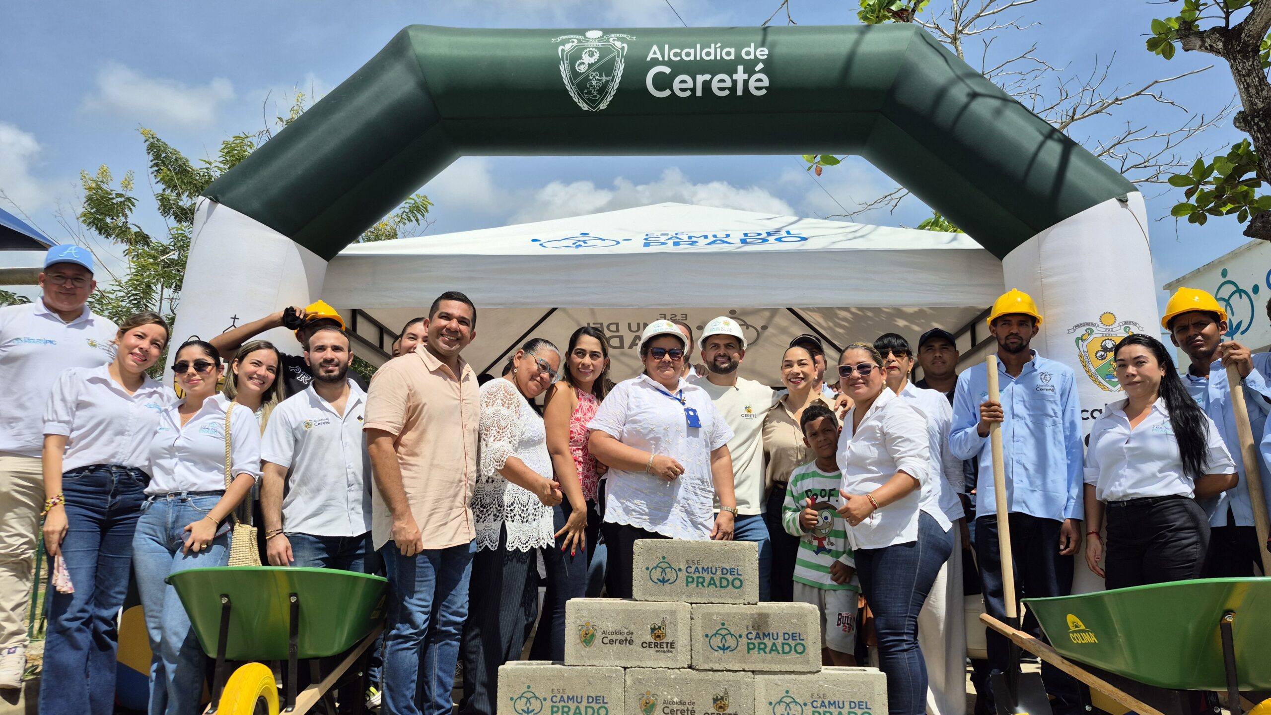 Funcionarios, trabajadores y miembros de la comunidad posan durante un acto institucional de inicio de obra, junto a bloques de construcción, carretillas y herramientas frente a la sede del CAMU del Prado.